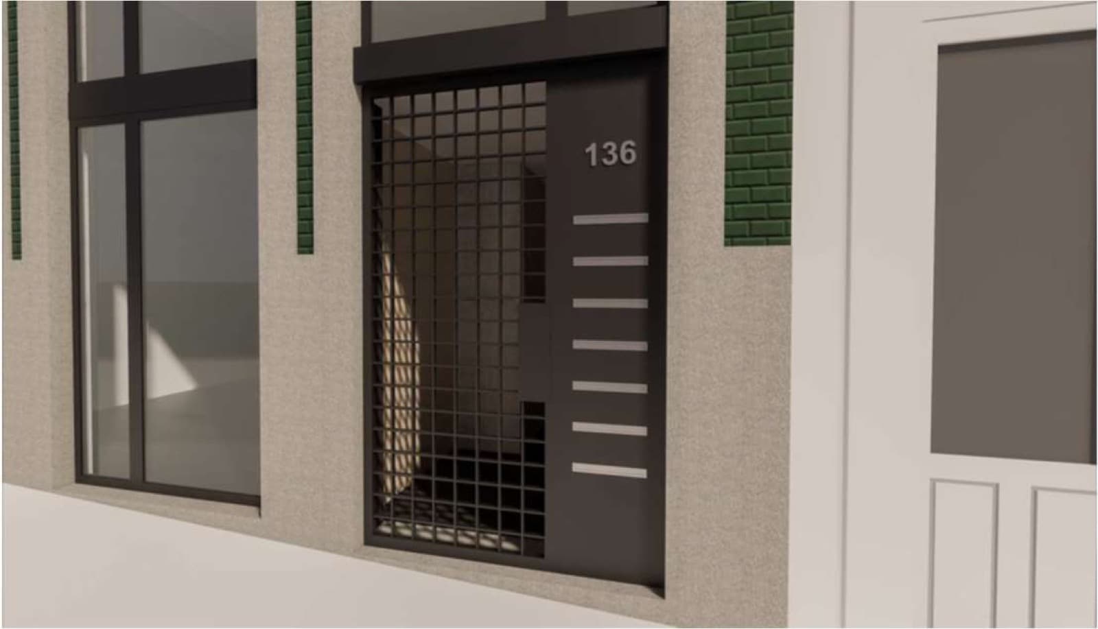 A entrada, na fachada verde com a porta em ferro